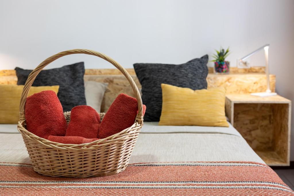 ポンタ・デルガダにあるCasa dos Guerra - Studio Apartmentsのベッドに座る赤いクッションが入ったバスケット
