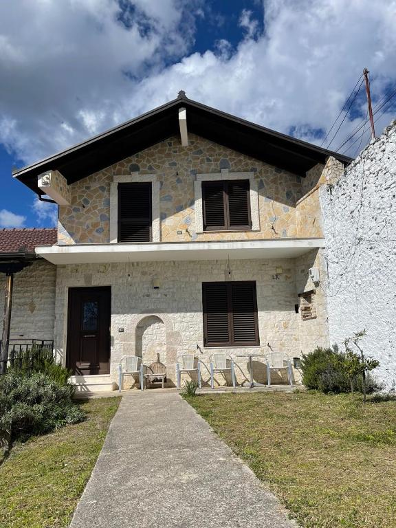 a stone house with chairs in front of it at Stone Villa Ballabanac in Krujë