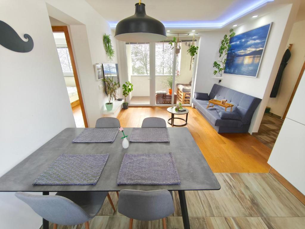 a dining room and living room with a table and chairs at Family Nest near Ljubljana with free parking in Dobrova