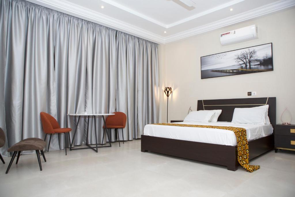 une chambre avec un lit, une table et des chaises dans l'établissement StayAfrica, à Ouagadougou