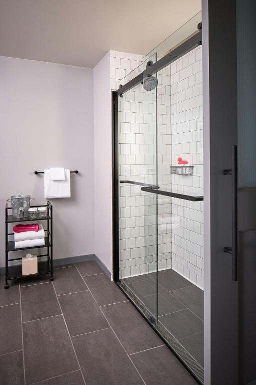 a bathroom with a shower with a glass door at MOXY Denver Cherry Creek in Denver