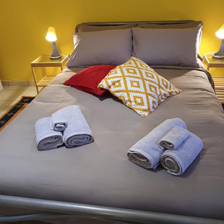 a bed with towels and pillows on it at Stelios apartment 2 in Chios