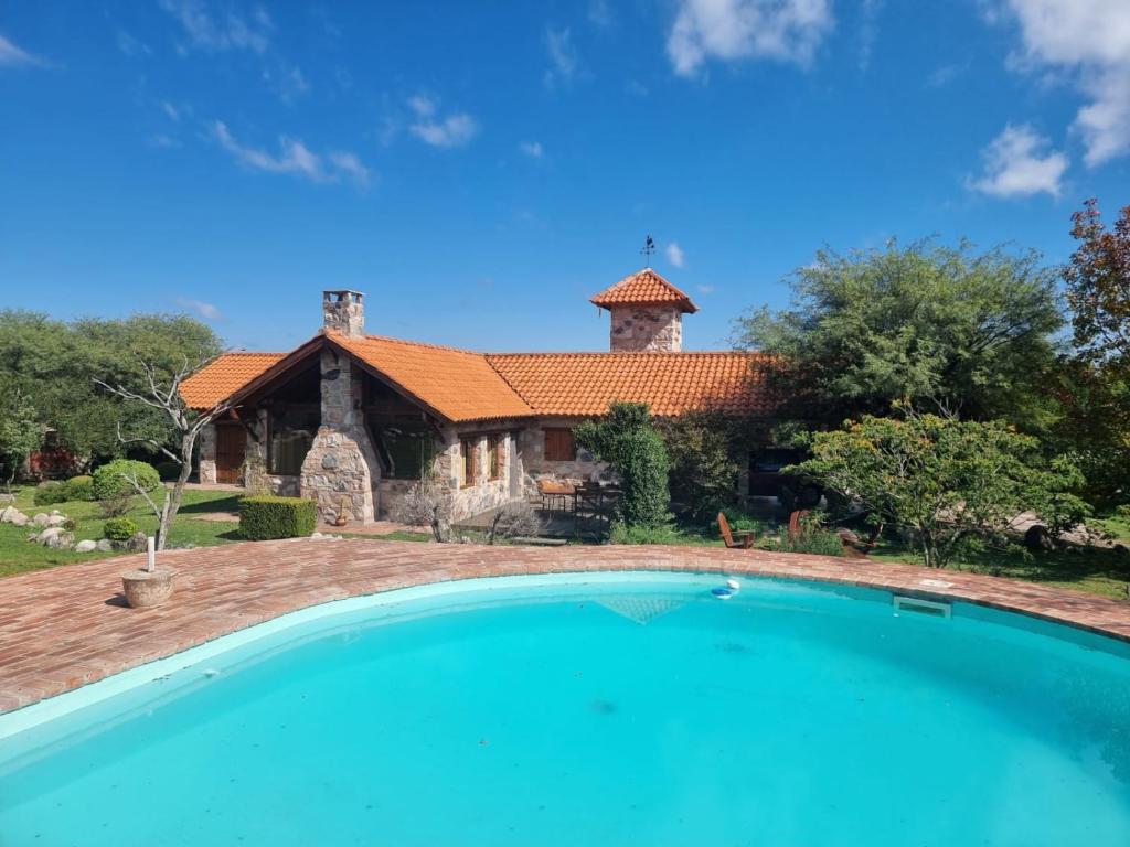 a house with a swimming pool in front of a house at Las Veronas in Villa de Las Rosas