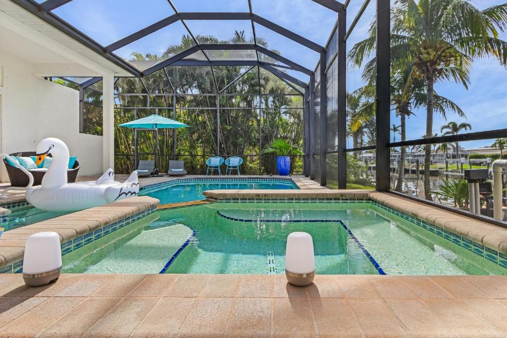 an indoor swimming pool with a large glass house at Villa Azurro, Cape Coral in Cape Coral