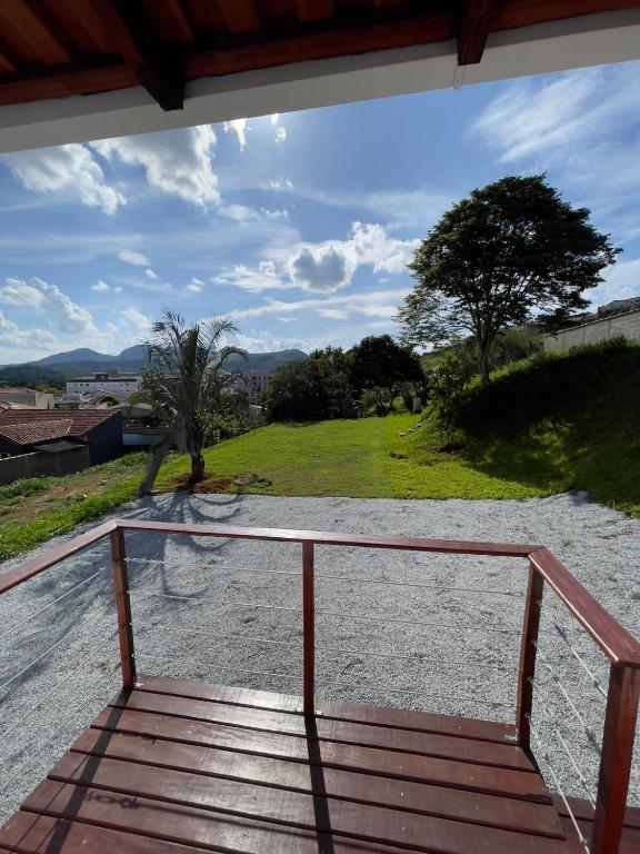 a wooden porch with a view of a field at Tiny Garden House in Santa Rita do Sapucaí