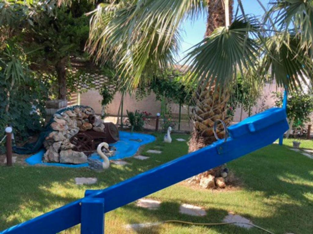 un parque infantil con un tobogán azul en un patio en Giannis Private Villa, With Garden, en Kalamaki