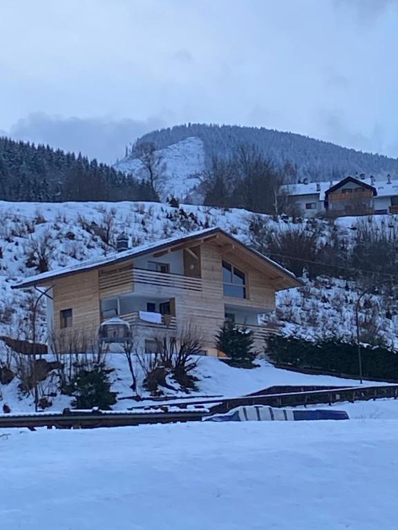 a house on a hill with snow on the ground at Lagorai Suites in Cavalese