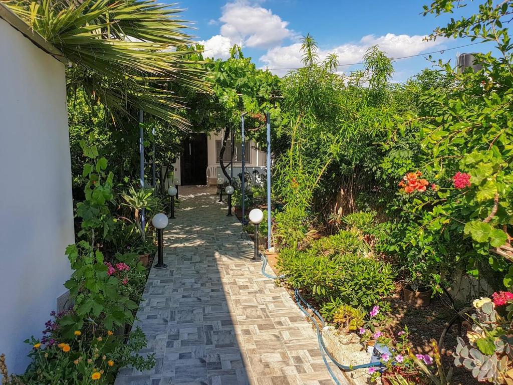a walkway in a garden with flowers and plants at Maria's House, With Garden in Kalamaki Heraklion