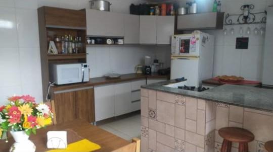 a kitchen with a counter and a refrigerator and a table at Casa da Suzy in Lençóis