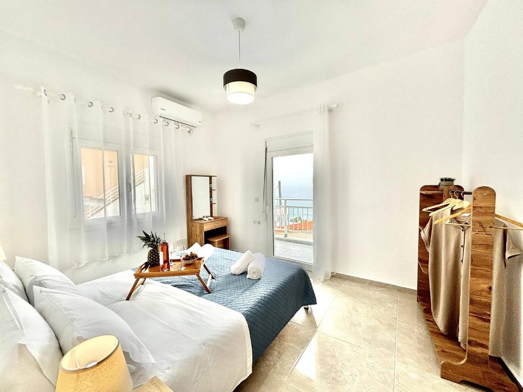 a white living room with a couch and a table at Nikos Apartment, With Seaview in Kalamaki Heraklion