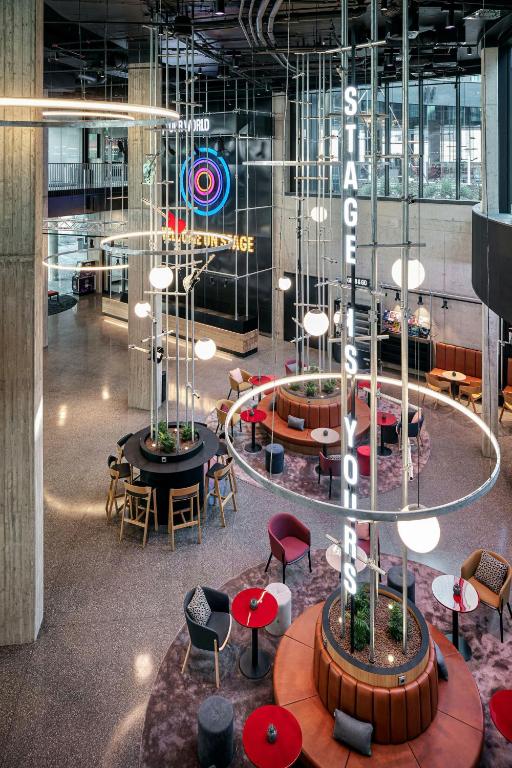 a lobby with tables and chairs in a building at STAGES HOTEL Prague, a Tribute Portfolio Hotel in Prague