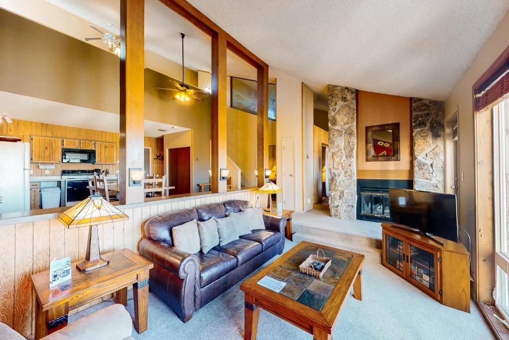 a living room with a leather couch and a tv at Mountainside 037 in Granby