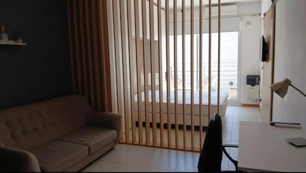 Una sala de estar con un sofá y una ventana grande. en Armónico en Bs As, en Buenos Aires