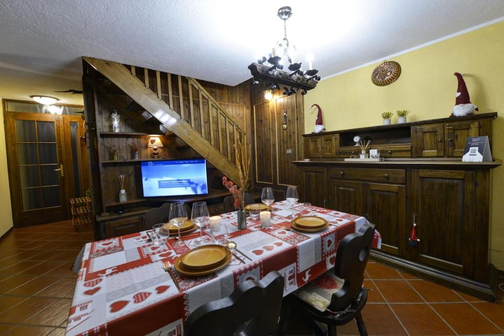 Un comedor con una mesa y un televisor. en Maison EsterLina, en Villaret