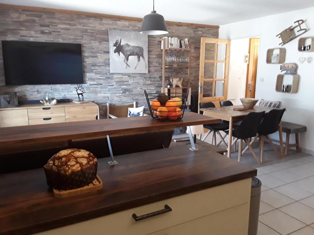 un salon avec une table et une télévision dans l'établissement Lumineux appt 2 chambres sur les hauteurs de Briançon, terrasse et garage, à Briançon
