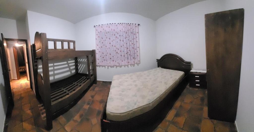 ein Schlafzimmer mit zwei Etagenbetten und einem Fenster in der Unterkunft Casa para Réveillon na praia in São Sebastião