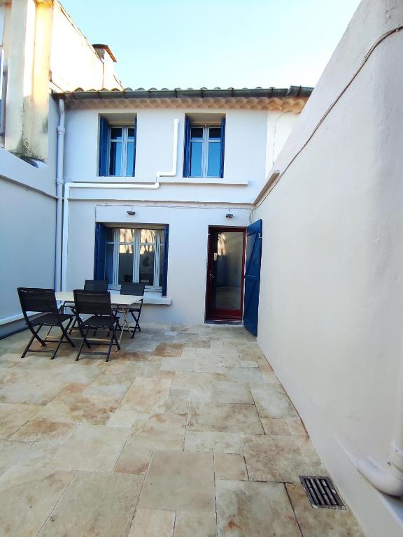 un patio avec des chaises et une table devant un bâtiment dans l'établissement Le Petit Gaffier, maison au pied de la Cité, avec 2 chambres et belle cour sans vis à vis, à Carcassonne