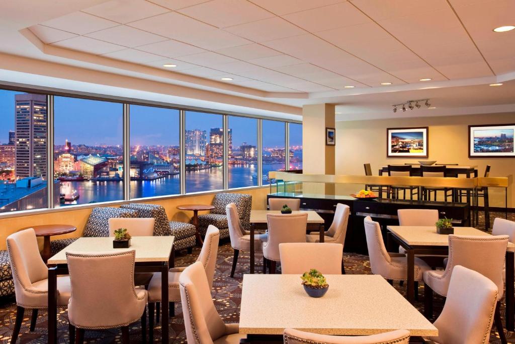a restaurant with tables and chairs and a view of the city at Sheraton Inner Harbor Hotel in Baltimore