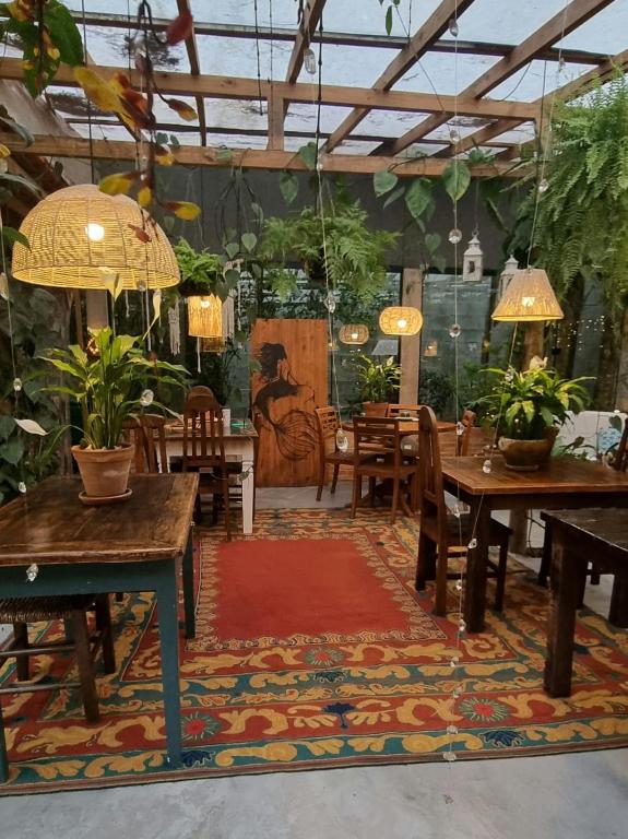 a dining room with tables and chairs and plants at Pousada Santarina in Florianópolis