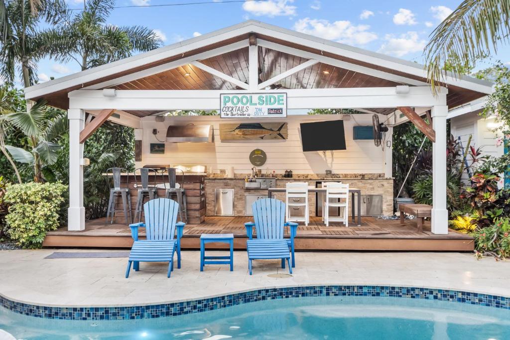 een bar bij het zwembad met blauwe stoelen en een barbecue bij het zwembad bij Trophy Fish at the Oasis in Ellenton