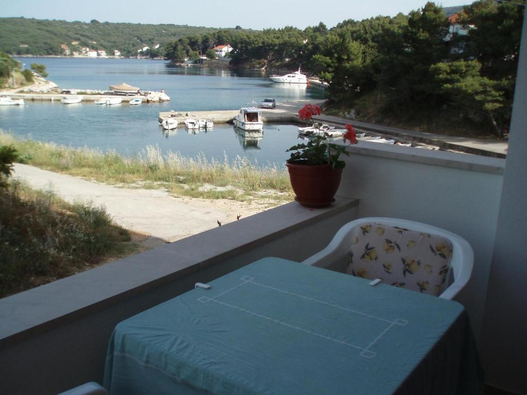 una mesa en un balcón con vistas al río en Apartment Marija en Brbinj