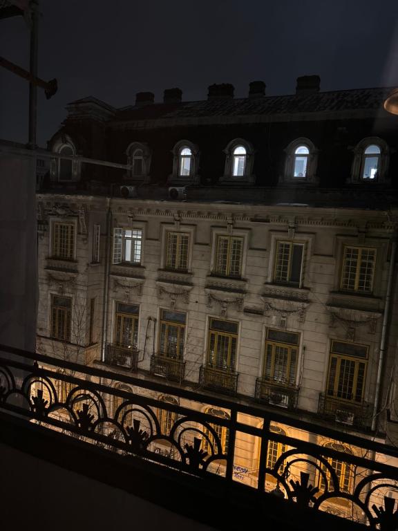 a large building with windows and a fence at night at CoolKUSH 2U in Bucharest