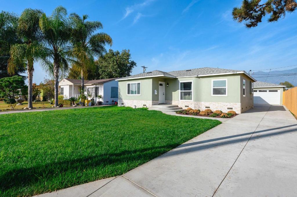 a house with a green lawn and palm trees at Luxury Modern Retreat with Spacious Yard & Premium Comfort in Monrovia