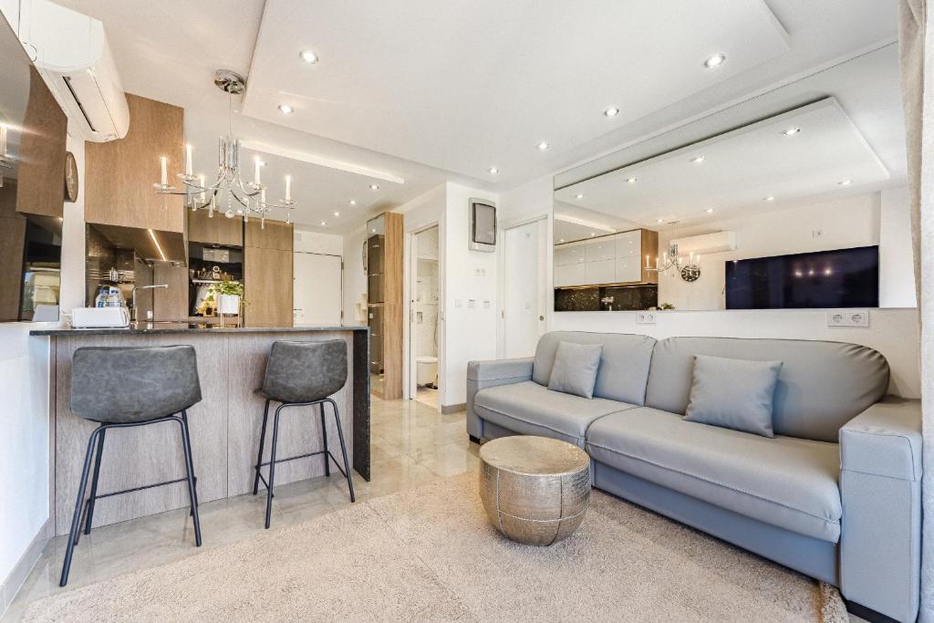 Una sala de estar con un sofá y una cocina. en Hermitage Homes TDS, en Playa de las Américas