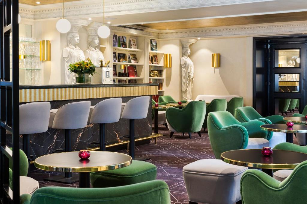 a bar with green chairs and tables in a restaurant at Hotel Barsey by Warwick in Brussels