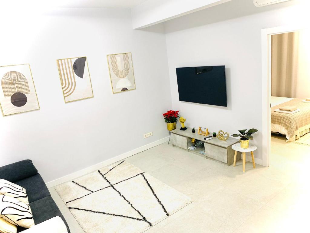 a white living room with a tv on a white wall at Céntrico estudio en Av Solidaridad in Logroño