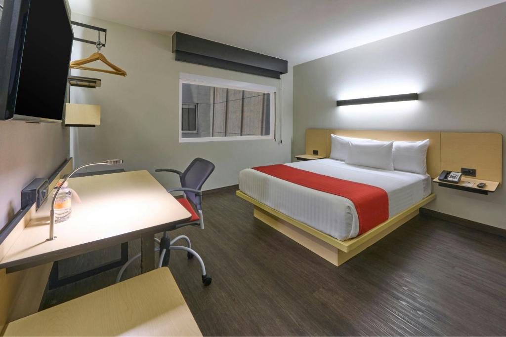 a hotel room with a bed and a desk at City Express by Marriott Ciudad de México La Villa in Mexico City