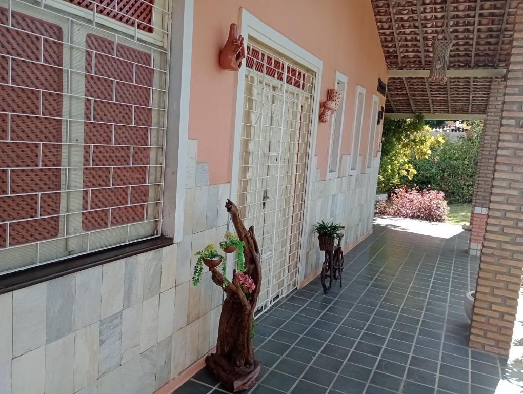 a porch of a house with two statues on it at Arte e Jardim na Atalaia Nova in Barra dos Coqueiros