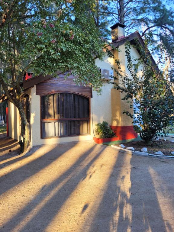 a house with a tree in front of a driveway at Complejo Turistico Chuy in Barra del Chuy