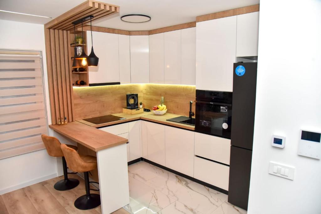 a kitchen with white cabinets and a wooden table at Apartman Ela in Križevci