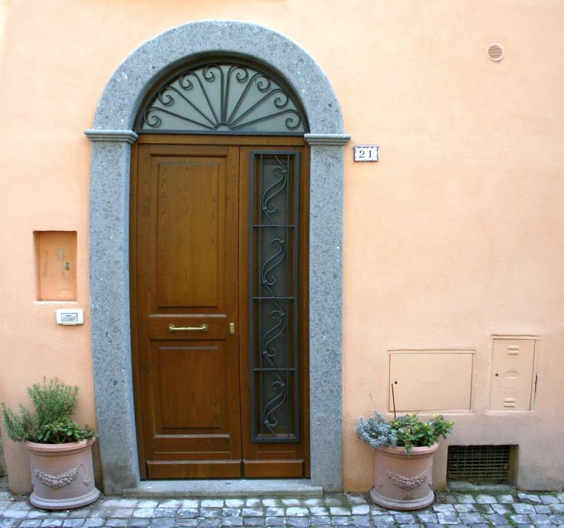 a wooden door in a building with two potted plants at Apartment Castel Gandolfo in Castel Gandolfo
