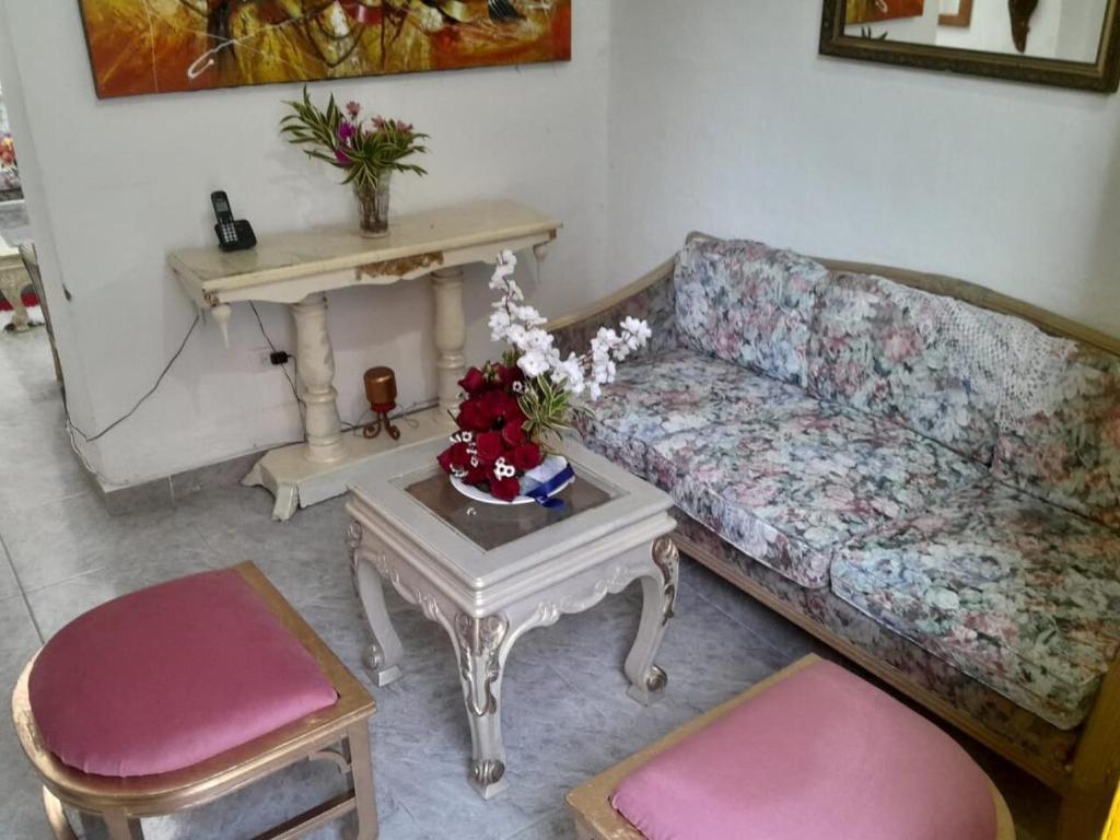 a living room with a couch and a table with flowers at Casa cerca a la placita de flores, el tranvia el metro, rodeada de restaurantes y comercio rentalsOP AN06 in Medellín