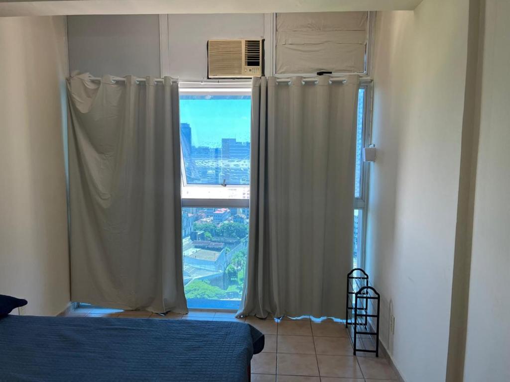 una camera da letto con finestra affacciata sulla città di Meu Apartamento a 5min do Sambódromo no Centro Econômico do Rio a Rio de Janeiro