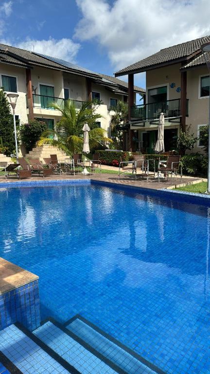 a large blue swimming pool in front of a building at Casa em Condomínio - Salinópolis in Salinópolis