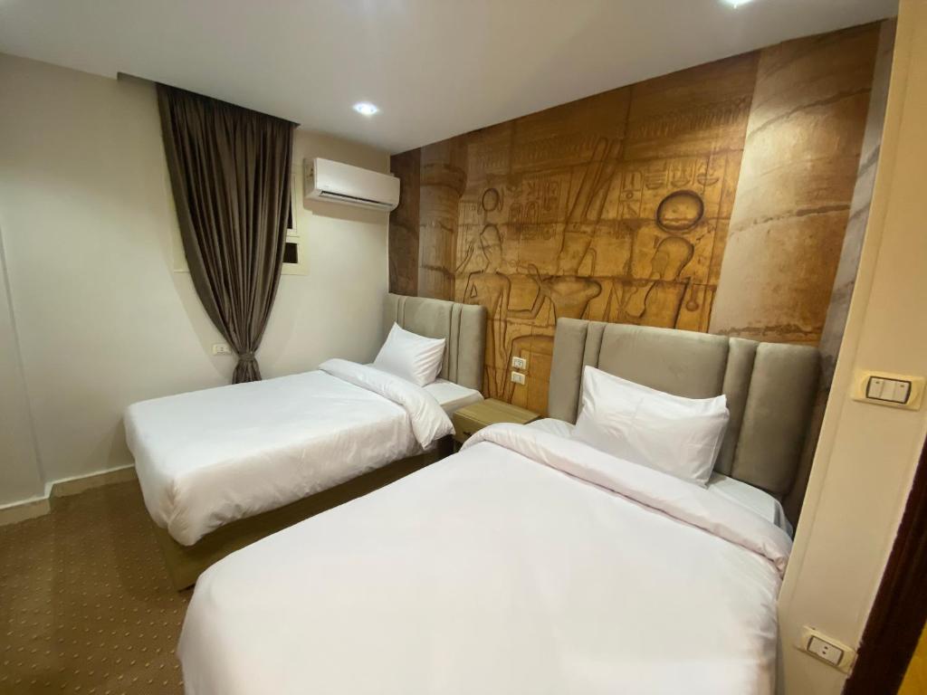 Postel nebo postele na pokoji v ubytování Royal Golden Pyramids Inn
