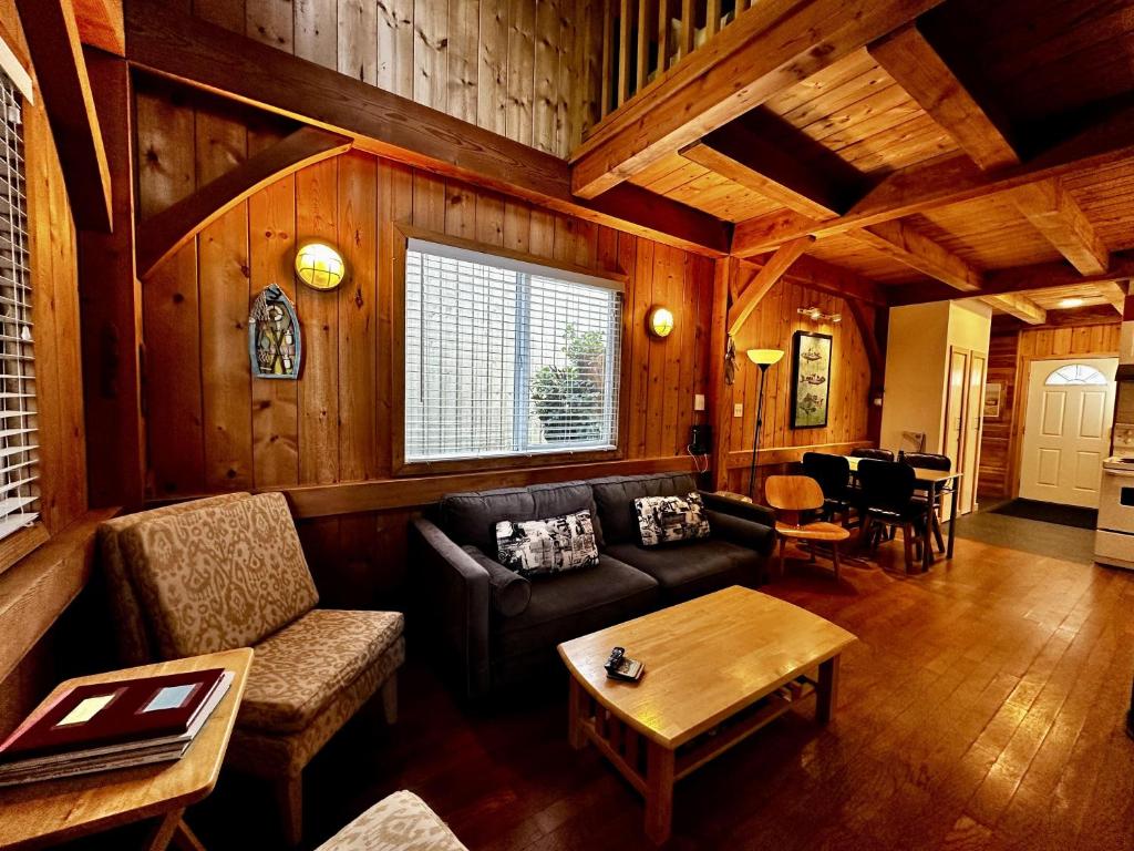 salon z kanapą i stołem w obiekcie Waterfront Timber Frame Cottage! w mieście Ucluelet