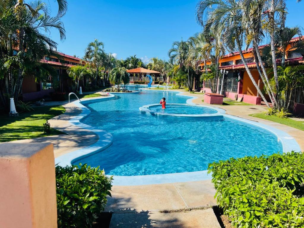 a pool at a resort with a person in it at Cómodo town-house con piscina in El Marite
