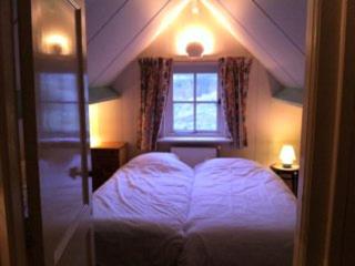 een slaapkamer met een bed en een raam bij Dune Bep in Schiermonnikoog