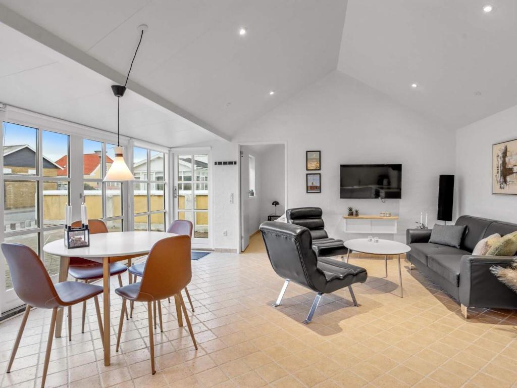 ein Wohnzimmer mit einer Couch und einem Tisch und Stühlen in der Unterkunft Charming Haven in Lokken - By Traum Ferienwohnungen in Løkken