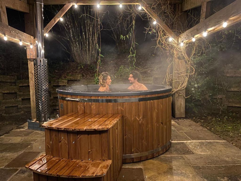- un bain à remous éclairé pour un homme et une femme dans l'établissement Spacieux Gîte Proche Forêt avec Sauna, Baby Foot et Activités Extérieures - À 10 min de Remiremont - FR-1-589-293, à Saint-Nabord