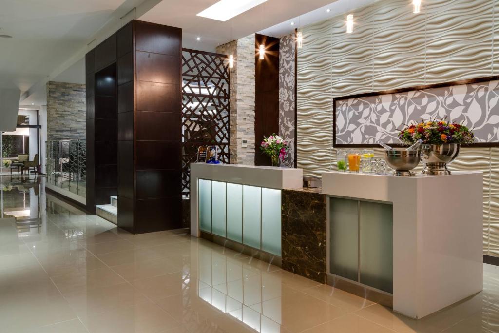 a lobby with a counter with flowers on it at Protea Hotel by Marriott Upington in Upington