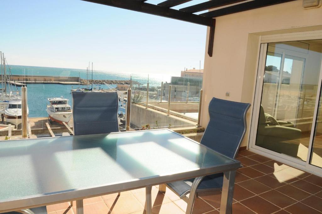 a table and chairs on a balcony with a view of a marina at Residencial Marina de Port in L'Ametlla de Mar