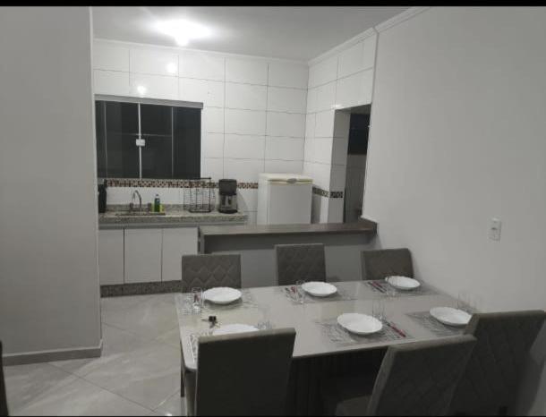 a kitchen with a table and chairs and a kitchen with a table and chairsktop at ap 22 amaryllis in Poços de Caldas