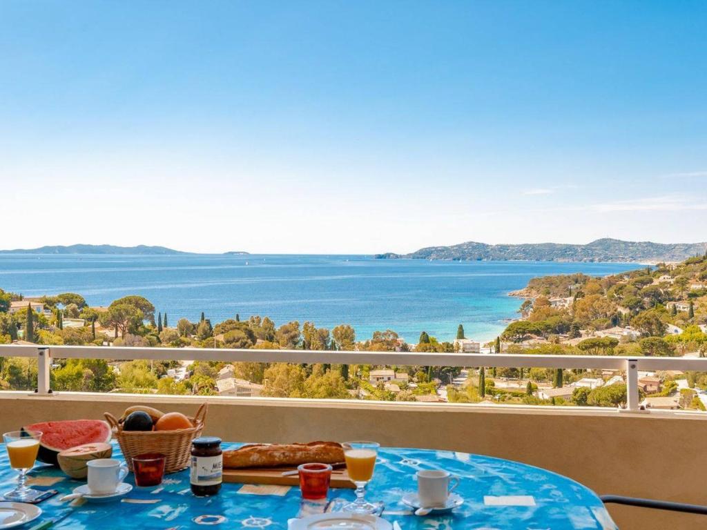 - une table avec de la nourriture et une vue sur l'océan dans l'établissement Appartement chaleureux avec terrasse et parking au Lavandou - FR-1-816-2, au Lavandou