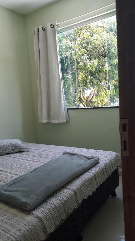un dormitorio con una cama y una ventana en Porto apartamento 1, en Porto Seguro