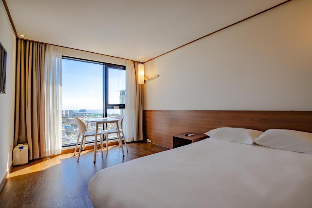 Postel nebo postele na pokoji v ubytování Tamara Jeju hotel